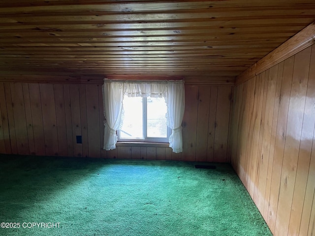 additional living space with wooden ceiling, wooden walls, and carpet