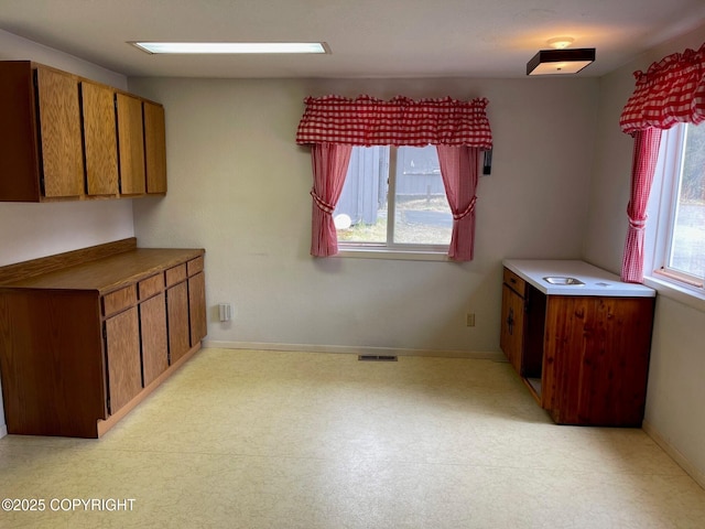 unfurnished dining area with baseboards and visible vents