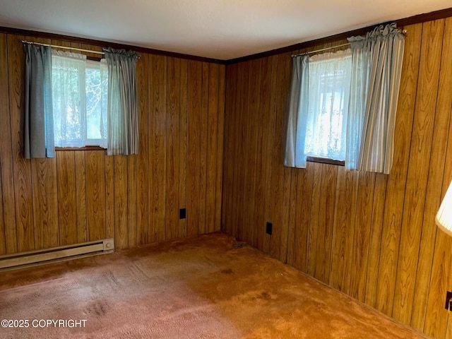 carpeted empty room with wood walls and baseboard heating
