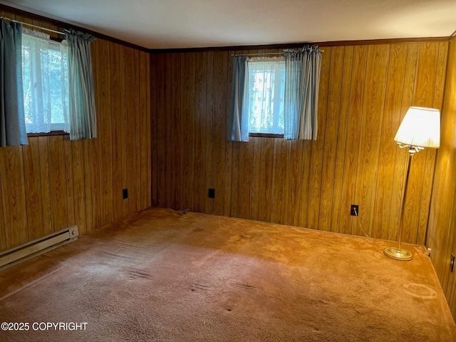 unfurnished room with a baseboard heating unit, carpet floors, and wooden walls