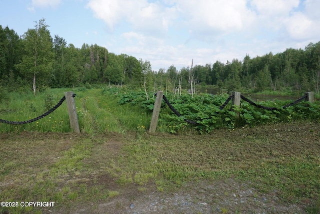 view of gate featuring a view of trees