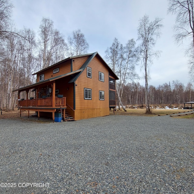 rear view of house with driveway, a porch, and a deck