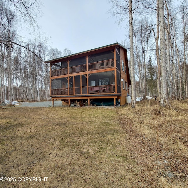 back of property featuring a wooden deck and a yard