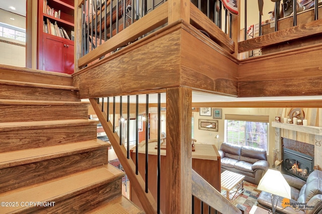 49635 S Hunter Dr, Willow, AK 99688 - staircase featuring a glass covered fireplace and a towering ceiling