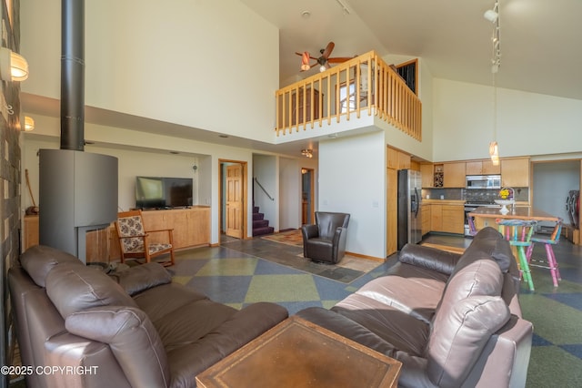 2435 Paradise Pl, Homer, AK 99603 - living room with high vaulted ceiling, stairway, ceiling fan, and dark floors