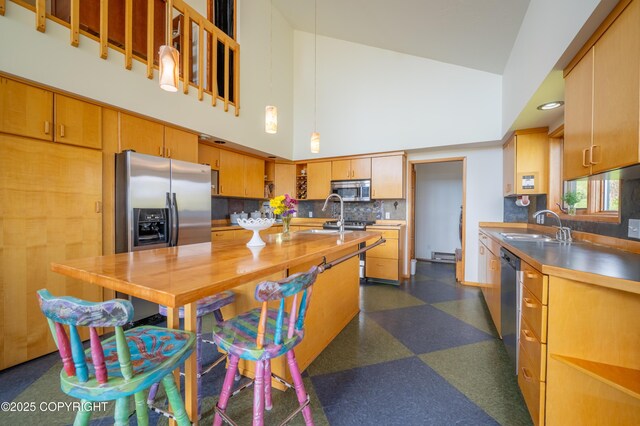 2435 Paradise Pl, Homer, AK 99603 - kitchen with appliances with stainless steel finishes, high vaulted ceiling, dark floors, tasteful backsplash, and a sink
