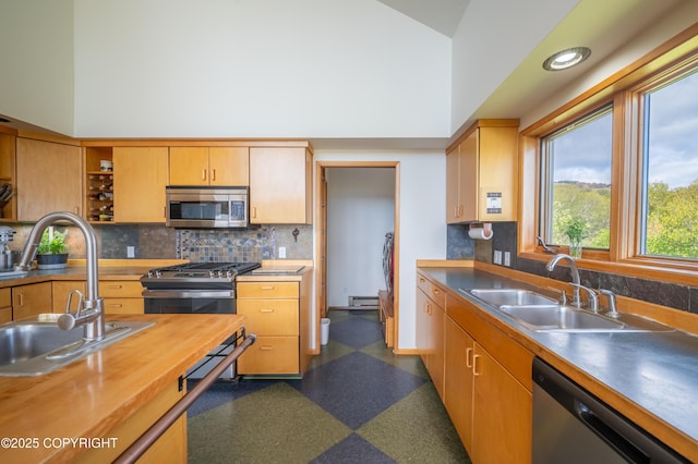 2435 Paradise Pl, Homer, AK 99603 - kitchen featuring appliances with stainless steel finishes, a sink, a baseboard heating unit, backsplash, and high vaulted ceiling