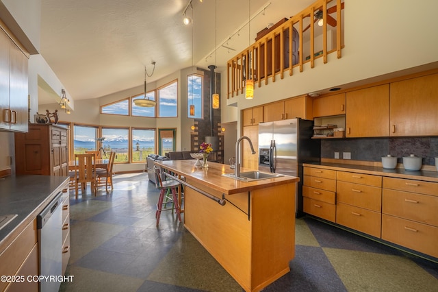 2435 Paradise Pl, Homer, AK 99603 - kitchen with a sink, high vaulted ceiling, stainless steel appliances, decorative backsplash, and a center island with sink