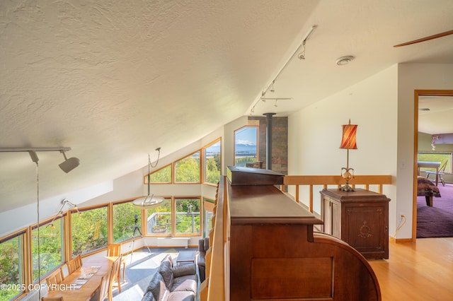 2435 Paradise Pl, Homer, AK 99603 - stairway featuring rail lighting, wood finished floors, a textured ceiling, a ceiling fan, and vaulted ceiling