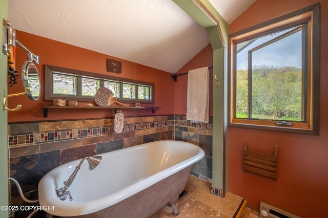 2435 Paradise Pl, Homer, AK 99603 - full bathroom featuring vaulted ceiling, a baseboard heating unit, a freestanding bath, and tile walls