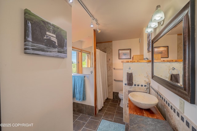 2435 Paradise Pl, Homer, AK 99603 - bathroom with toilet, rail lighting, tile patterned floors, a shower with shower curtain, and vanity