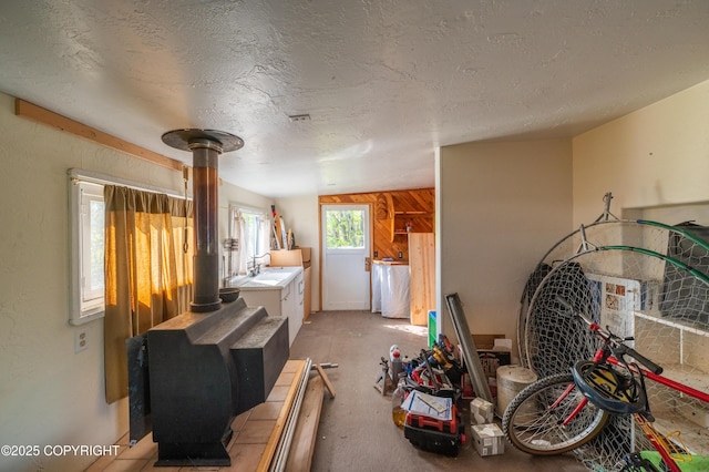 2435 Paradise Pl, Homer, AK 99603 - interior space with a wood stove, a textured ceiling, and light colored carpet