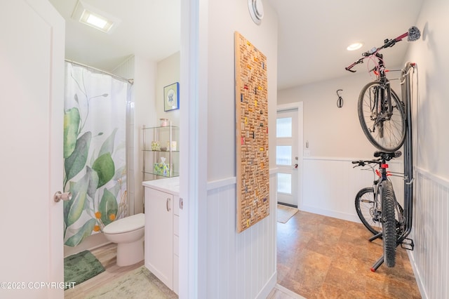 437 W Fairview Ave, Homer, AK 99603 - bathroom featuring a wainscoted wall, toilet, and a shower with curtain