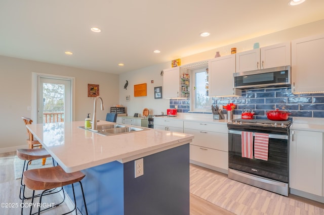 437 W Fairview Ave, Homer, AK 99603 - kitchen featuring appliances with stainless steel finishes, a sink, an island with sink, recessed lighting, and a breakfast bar
