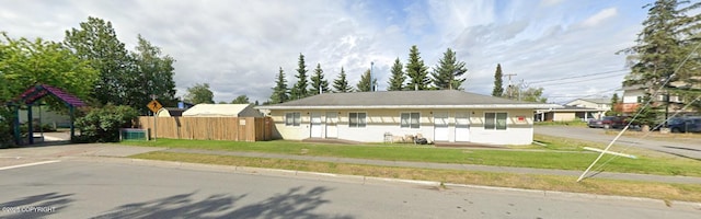 view of front of property with fence and a front lawn