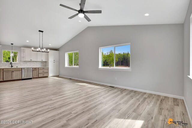3696 S Alvaro Dr, Wasilla, AK 99654 - unfurnished living room with ceiling fan, vaulted ceiling, recessed lighting, light wood finished floors, and a chandelier