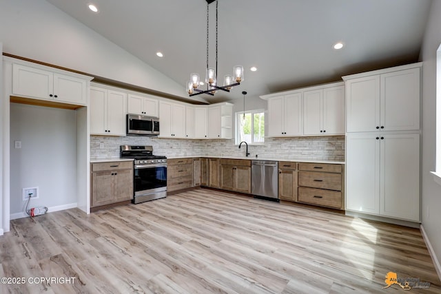 3696 S Alvaro Dr, Wasilla, AK 99654 - kitchen with appliances with stainless steel finishes, backsplash, pendant lighting, white cabinets, and lofted ceiling
