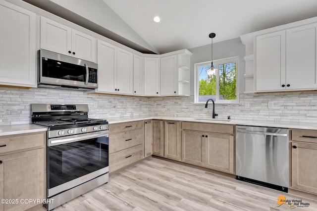 3696 S Alvaro Dr, Wasilla, AK 99654 - kitchen featuring appliances with stainless steel finishes, open shelves, vaulted ceiling, light countertops, and hanging light fixtures