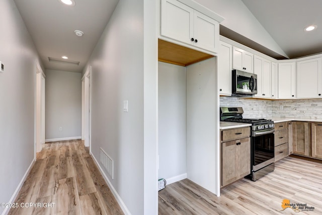 3696 S Alvaro Dr, Wasilla, AK 99654 - kitchen featuring appliances with stainless steel finishes, light wood-type flooring, tasteful backsplash, light countertops, and white cabinetry