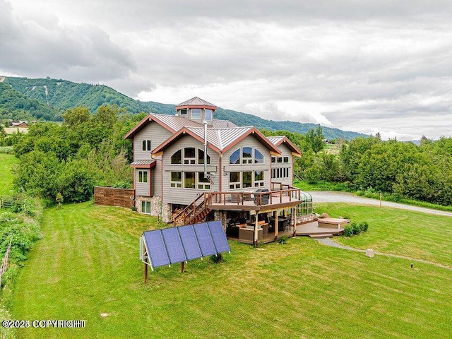 41345 Alan St, Homer, AK 99603 - rear view of property featuring a deck with mountain view, a lawn, stairs, and metal roof