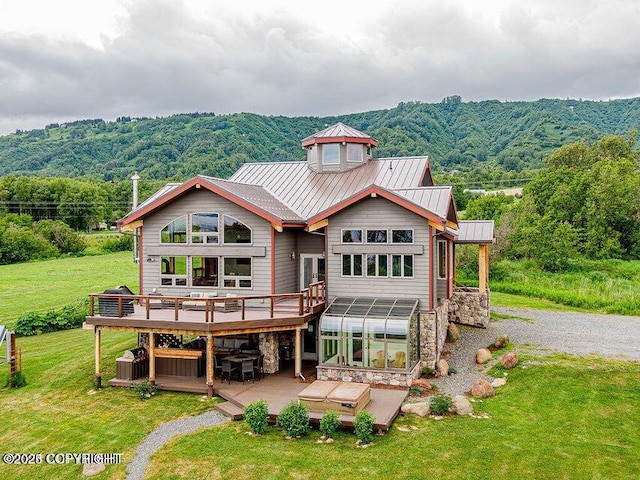 41345 Alan St, Homer, AK 99603 - back of property featuring a jacuzzi, a deck, stone siding, metal roof, and a standing seam roof