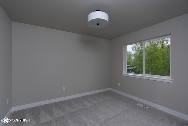 unfurnished room with carpet flooring and baseboards