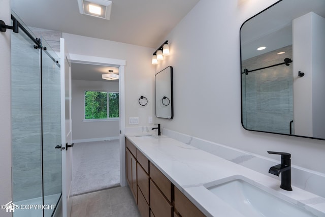 bathroom featuring a shower stall, tile patterned flooring, double vanity, and baseboards