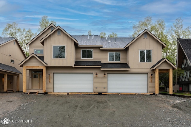 view of front of home with board and batten siding, a garage, and a shingled roof