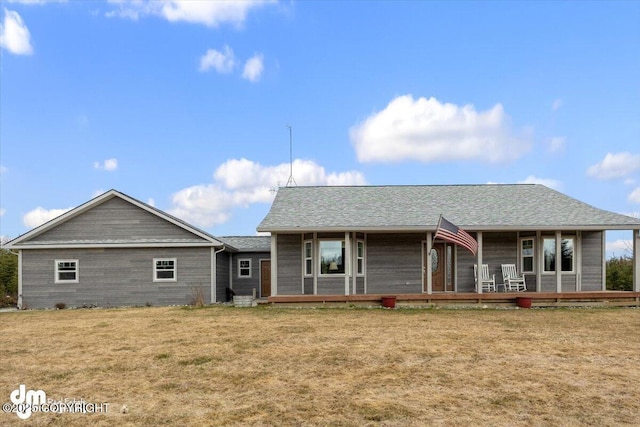 view of front of house featuring a porch, a shingled roof, and a front lawn