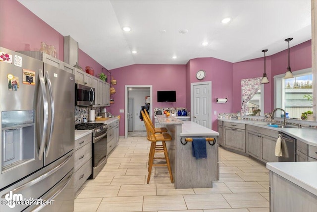kitchen featuring light countertops, a sink, lofted ceiling, and stainless steel appliances