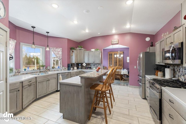kitchen featuring light countertops, appliances with stainless steel finishes, lofted ceiling, and tasteful backsplash