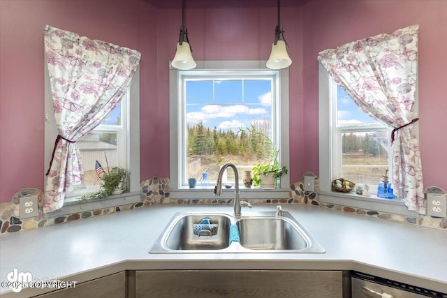 kitchen featuring stainless steel dishwasher, pendant lighting, a healthy amount of sunlight, and a sink