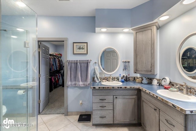bathroom featuring a sink, tile patterned flooring, and a shower stall