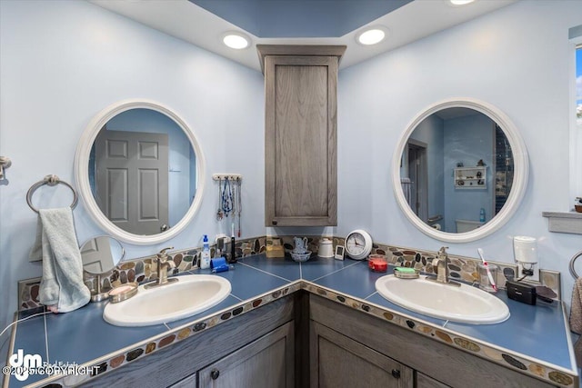 bathroom with a sink, recessed lighting, and double vanity
