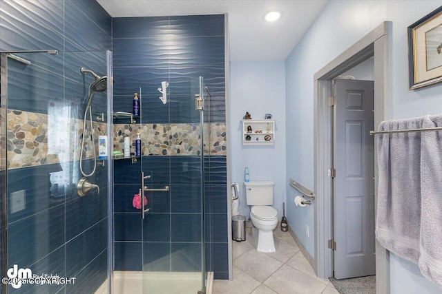 bathroom with tile patterned floors, toilet, and a shower stall