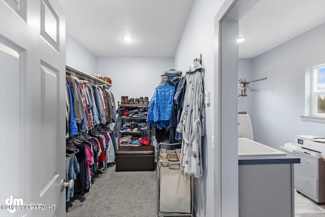walk in closet featuring light colored carpet