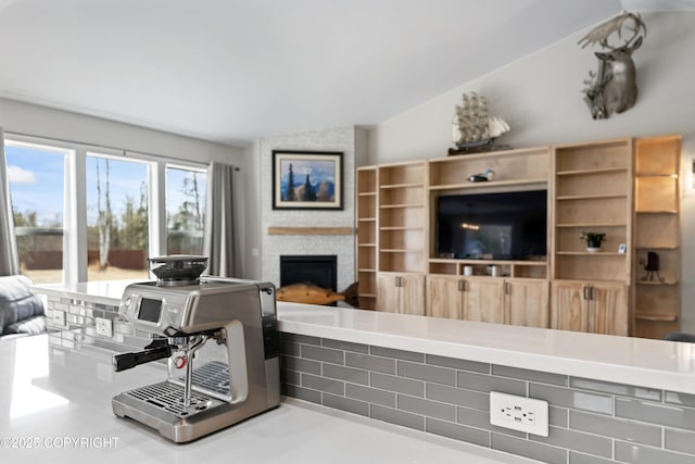 living area featuring vaulted ceiling and a fireplace