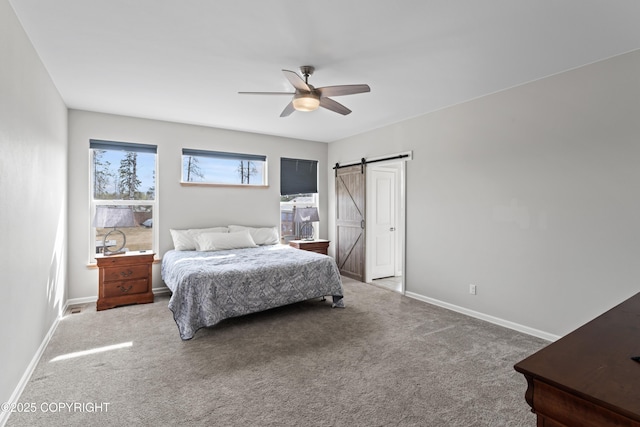 bedroom with baseboards, a barn door, a ceiling fan, and carpet