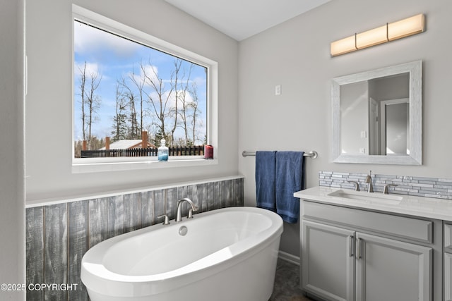 bathroom featuring vanity, a soaking tub, and tasteful backsplash