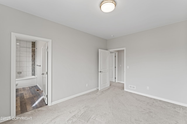 unfurnished bedroom featuring baseboards, visible vents, connected bathroom, and carpet flooring