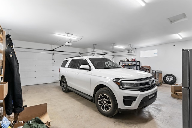 garage with a garage door opener and freestanding refrigerator