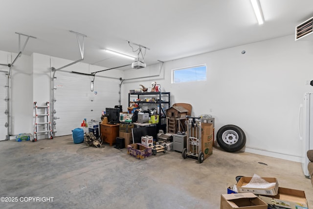 garage featuring a garage door opener and freestanding refrigerator
