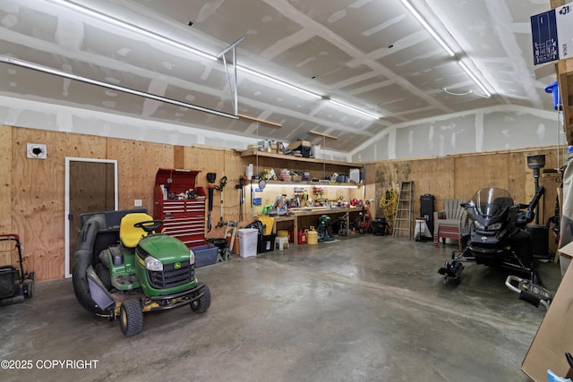 garage featuring wood walls and a workshop area