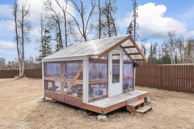 view of greenhouse featuring a fenced backyard