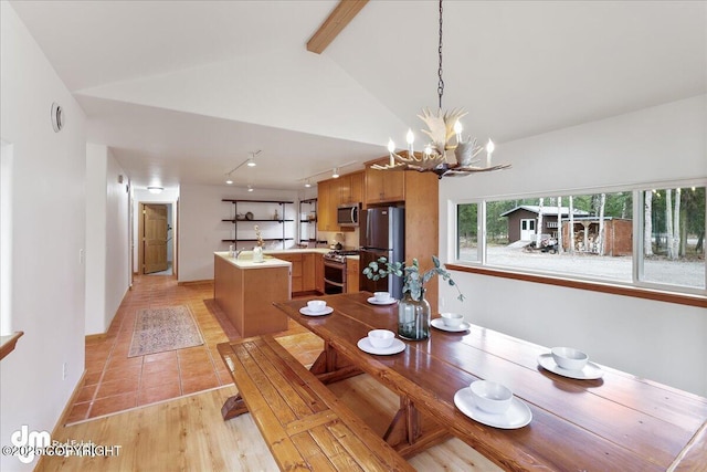 dining room with light tile patterned flooring, track lighting, a chandelier, baseboards, and vaulted ceiling with beams