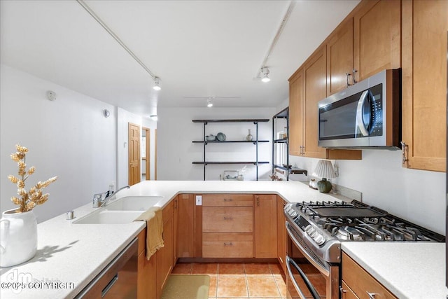 kitchen featuring light countertops, appliances with stainless steel finishes, light tile patterned floors, and a sink