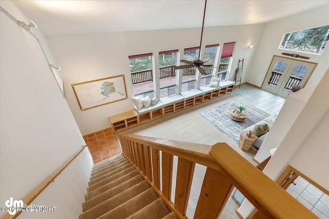 stairs with french doors, ceiling fan, and tile patterned flooring
