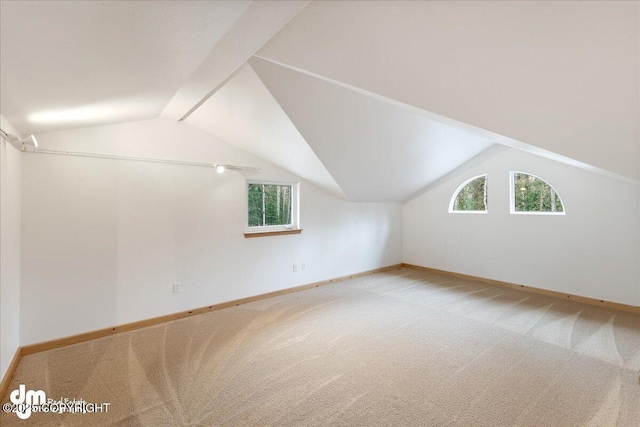 bonus room featuring baseboards, lofted ceiling, a wealth of natural light, and carpet