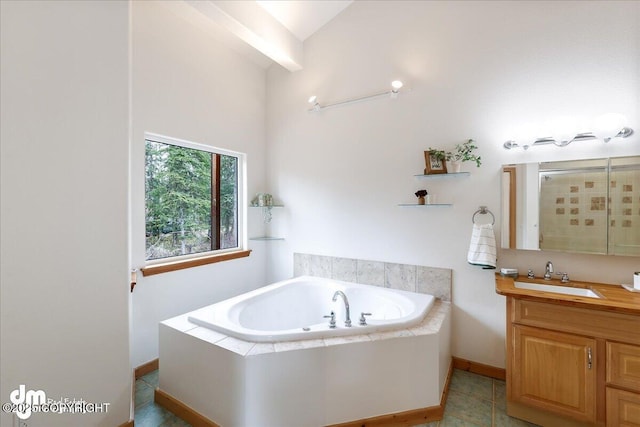 full bath with a garden tub, vanity, baseboards, a shower stall, and vaulted ceiling
