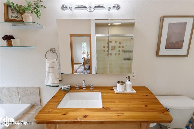 bathroom with vanity, a stall shower, toilet, and a garden tub